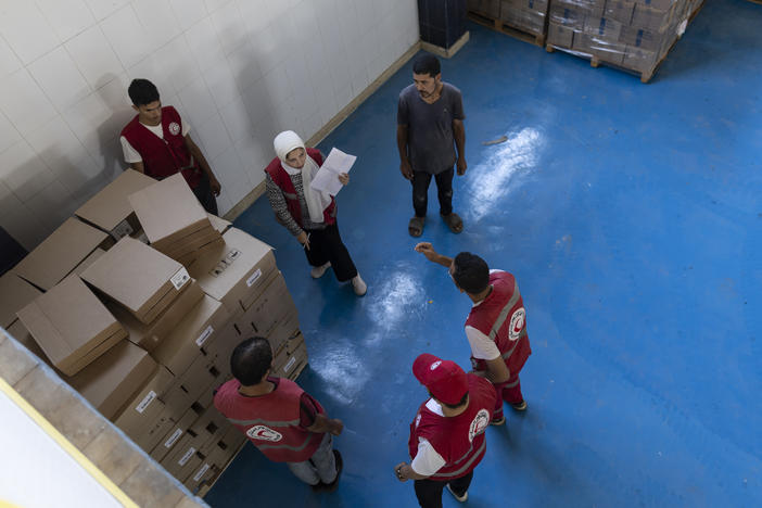 Workers stack supplies on Sunday at one of the warehouses in North Sinai, Egypt, where the Egyptian Red Crescent stores foreign aid destined for Gaza. The aid convoy, organized by a group of Egyptian NGOs, set off from Cairo for the Gaza-Egypt border crossing at Rafah.