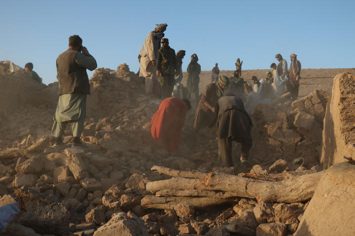 Afghan residents clear debris from a damaged house after an earthquake in the Zendeh Jan district of Herat province on Oct. 7.