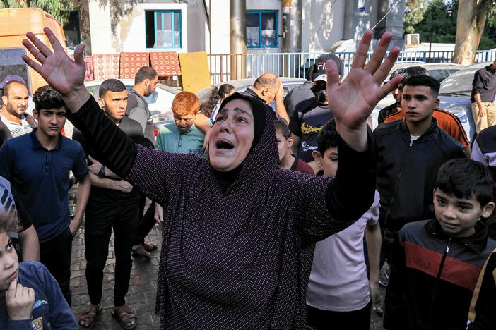 A woman reacts as people gather at the site of Al Ahli Arab hospital in central Gaza on Wednesday in the aftermath of an overnight explosion there.