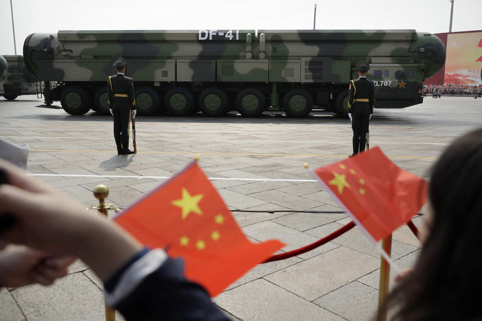 Spectators wave Chinese flags as military vehicles carrying DF-41 ballistic missiles roll during a parade to commemorate the 70th anniversary of the founding of Communist China in Beijing, Oct. 1, 2019. The latest assessment from the defense department said China had increased its arsenal of operational nuclear warheads from the estimated 400 in 2021 to more than 500 as of May this year.
