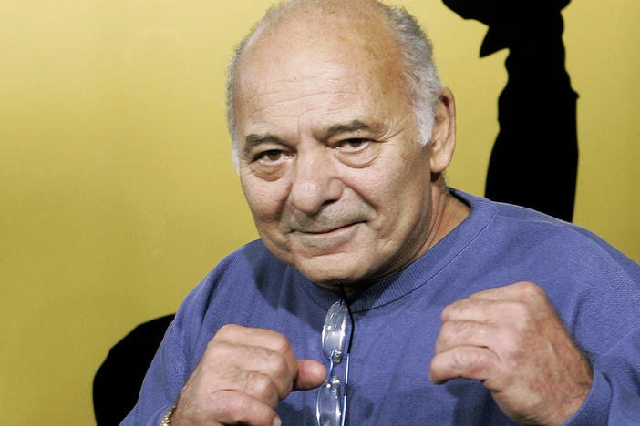 Burt Young, a cast member of the film "Rocky Balboa," gestures at the premiere in Los Angeles on Dec. 13, 2006. The Oscar-nominated actor who played Paulie, the rough-hewn, mumbling-and-grumbling best friend, corner-man and brother-in-law to Sylvester Stallone in the Rocky franchise, has died.