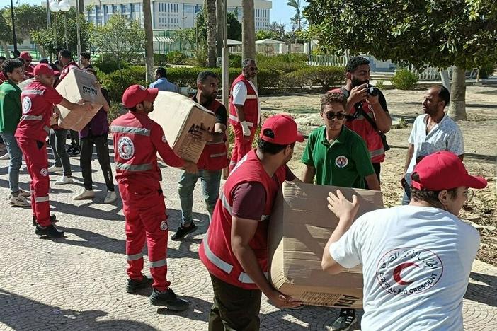 Workers load the trucks with boxes after a planes carrying Turkish humanitarian aid for residents of the Gaza Strip landed at El Arish International Airport in Egypt, neighboring the enclave under intense Israeli blockade and bombardment on October 13, 2023.