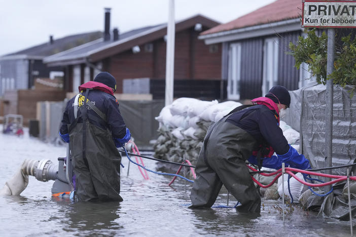 People try to pump water away in a flooded neighborhood in Haderslev, Denmark, on Friday.