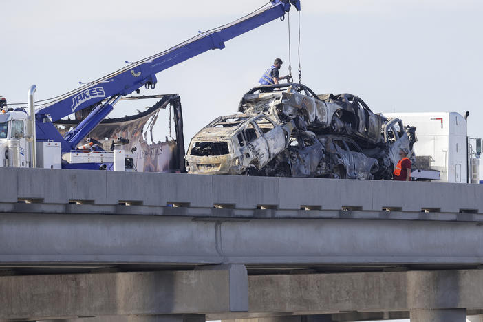 Workers remove heavily damaged vehicles from Interstate 55 near Manchac, La., on Monday.
