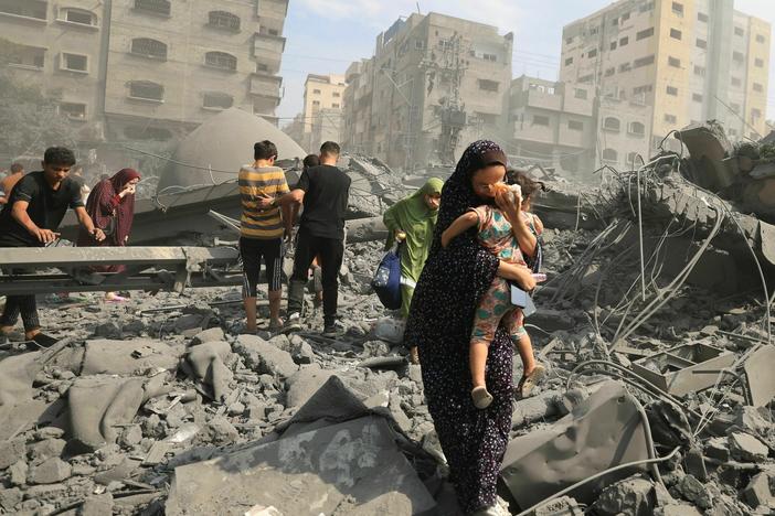 Palestinians evacuate the area following an Israeli airstrike on the Sousi mosque in Gaza City on October 9, 2023.