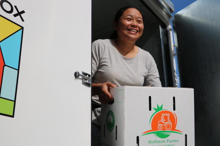 Hanmei Hoffman and her husband Derrick Hoffman farm in Greeley, Colorado, where most of their produce is sold to schools. Here she's moving boxes of cucumbers from a refrigerated container and loading them onto a waiting truck to deliver them to schools along Colorado's Front Range.