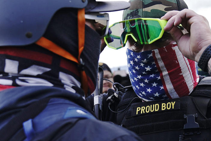 In this file photo, a member of the Proud Boys, right, stands in front of a counter protester as members of the Proud Boys and other right-wing demonstrators rally on Sept. 26, 2020.