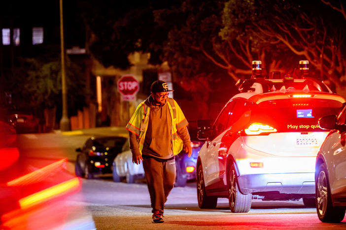 A Cruise technician comes to restart a driverless car in San Francisco.
