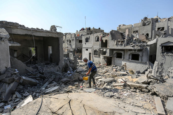 A local citizen searches through buildings which were destroyed during Israeli air raids in the southern Gaza Strip on Monday in Khan Younis, Gaza.