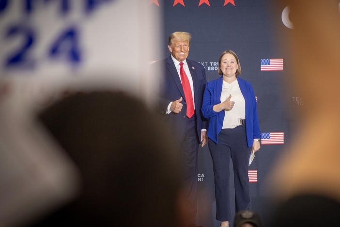 Former President Donald Trump stands on stage during a rally in suburban Des Moines with Iowa Attorney General Brenna Bird after receiving her endorsement on Oct. 16.