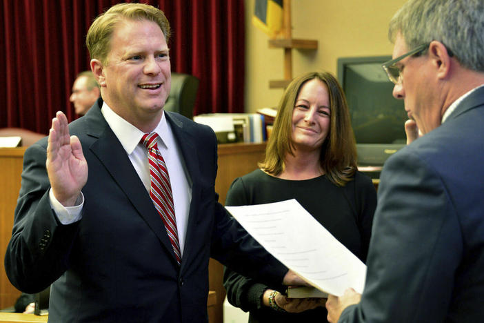 Washington County Circuit Court Clerk Kevin Tucker (right) swears in Andrew Wilkinson as a circuit court judge on Jan. 10, 2020, as Wilkinson's wife, Stephanie, watches.