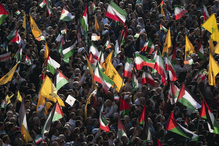 People carry Palestinian flags, Iranian flags and Hezbollah flags at Tehran's Revolution Square during an anti-Israel rally on Oct. 18.