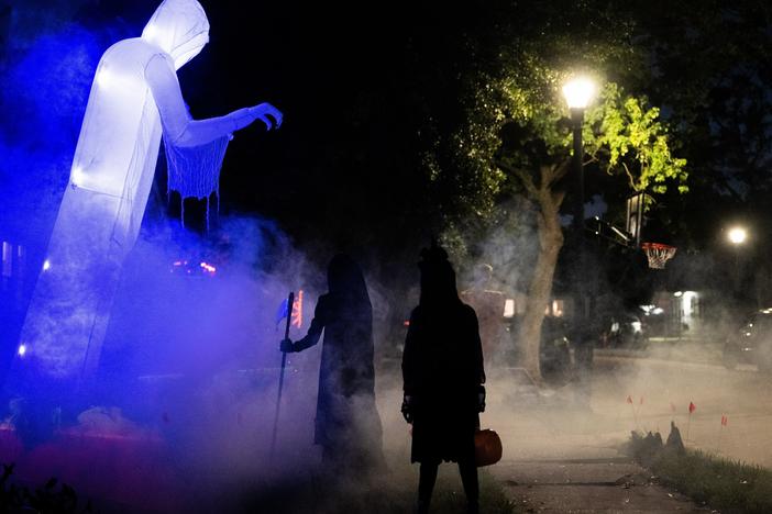 Children walk past Halloween decorations last year. In several U.S. towns, it's illegal for kids over 12 years old to go trick-or-treating.