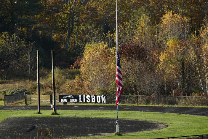 An American flag is set to half mast Saturday on a football field in Lisbon Falls, Maine, just a few hundred yards from a recycling facility where law enforcement found the body of Robert Card, the suspect in this week's mass shootings.