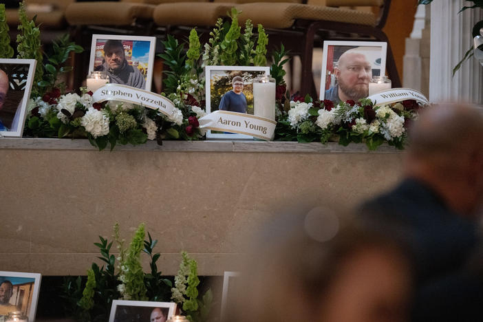 Photos of some of the victims of the Lewiston mass shooting are seen during the vigil.