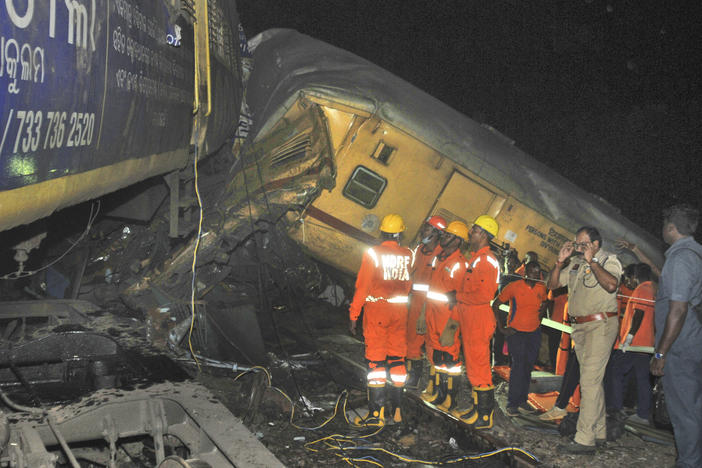 Rescuers and others stand after two passenger trains collided in Vizianagaram district, Andhra Pradesh state, India, Sunday, Oct.29, 2023.