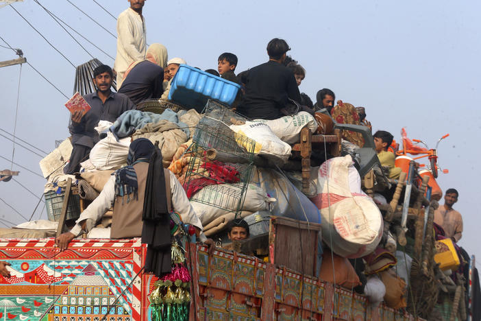 Afghan families ride on a truck heading to a border crossing in Torkham, Pakistan, Tuesday, before the expiration of a Pakistani deadline for those who are in the country illegally to leave or face deportation. Pakistan's crackdown has worried thousands of Afghans in the country awaiting relocation to the United States under a special refugee program since fleeing the Taliban takeover.