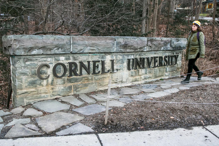 A woman walks by a Cornell University sign on the Ivy League school's campus in Ithaca, New York, on Jan. 14, 2022. Cornell University administrators dispatched campus police to a Jewish center after threatening statements appeared on a discussion board Sunday, Oct. 29, 2023.