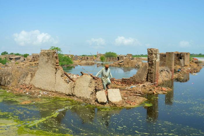 A man walks over his collapsed mud house after heavy monsoon rains in Pakistan in 2022. Climate change makes heavy rain more common, because a hotter atmosphere can hold more moisture.
