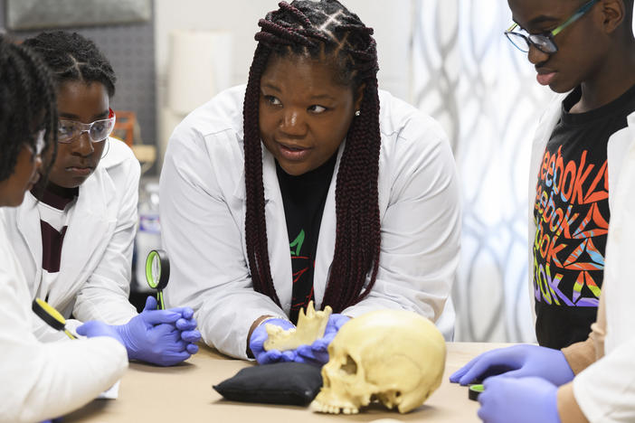 Using a plastic skull, archaeologist Alicia Odewale teaches a lesson about Tulsa's ongoing search for mass graves containing victims of the city's 1921 race massacre. She taught it at Black History Saturdays, a free private program designed for students to learn unvarnished lessons in African American history that teachers say a new law targeting race education has made harder to honestly teach.