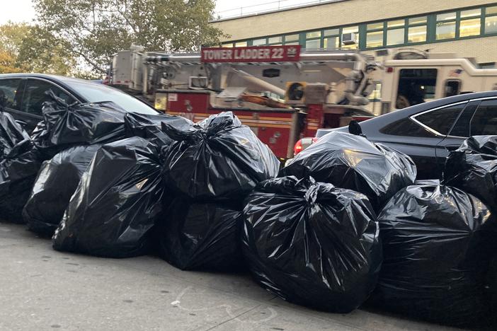 Trash bags sit on a sidewalk to be picked up by sanitation workers in Manhattan, New York City in October 2023.