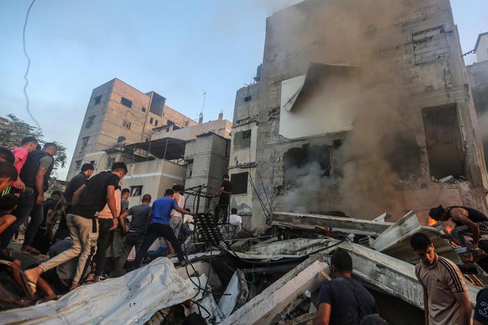 People search through buildings that were destroyed during Israeli air raids in the southern Gaza Strip on Saturday in Khan Younis, Gaza.