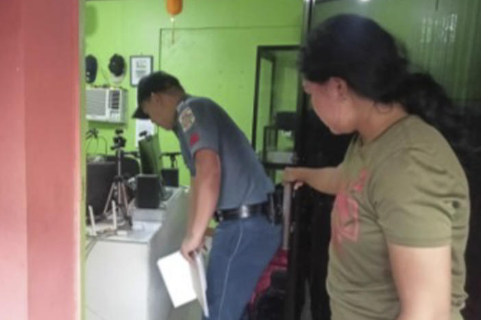 A policeman checks on the area where a radio anchor was fatally shot by a man inside his home-based station on Sunday, Nov. 5, 2023, in this handout photo provided by the Calamba Municipal Police Station. The brazen attack was witnessed by people watching the program live on Facebook.