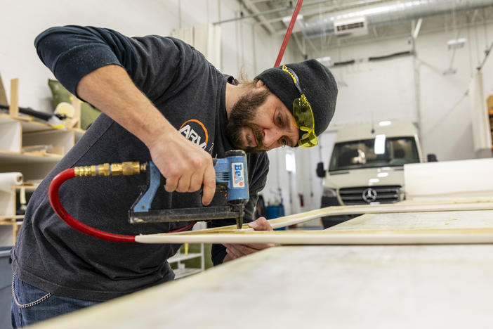 Bill Kowalcic works on wall panels in the finishing department at Advanced RV. After the company went to a four-day workweek, his team figured out how to cut time without cutting corners.