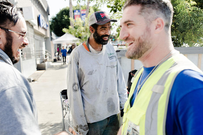 Veterans John Follmer, right, and Alejandro Rocha, left, do outreach on on Hollywood Boulevard in Los Angeles. They met Chris Brown, center, and offered to connect him with veterans services.