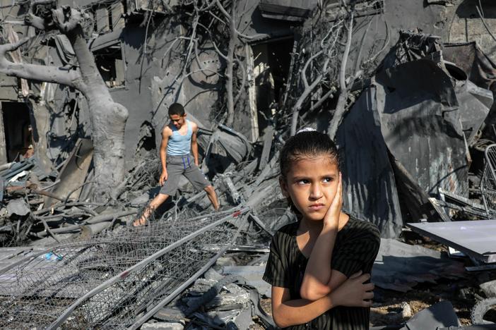 A girl looks on as she stands by the rubble outside a building hit by Israeli bombardment in the southern Gaza Strip on October 31, 2023. Children in Gaza have been exposed to high levels of violence even before the current war, researchers say, increasing their risk of mental health challenges.