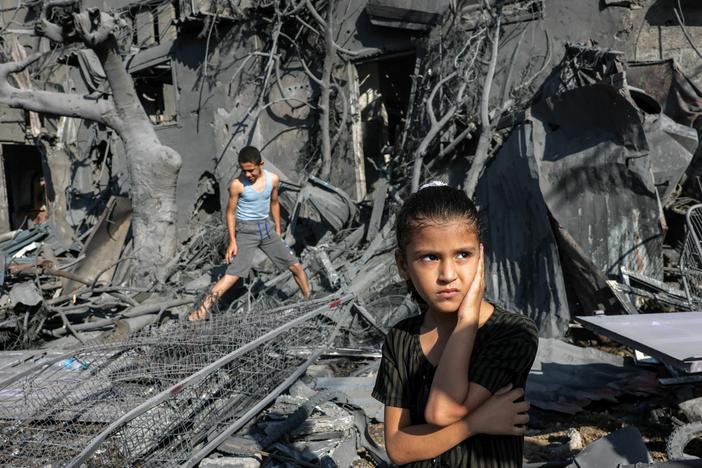 A girl looks on as she stands by the rubble outside a building hit by Israeli bombardment in the southern Gaza Strip on October 31, 2023. Children in Gaza have been exposed to high levels of violence even before the current war, researchers say, increasing their risk of mental health challenges.