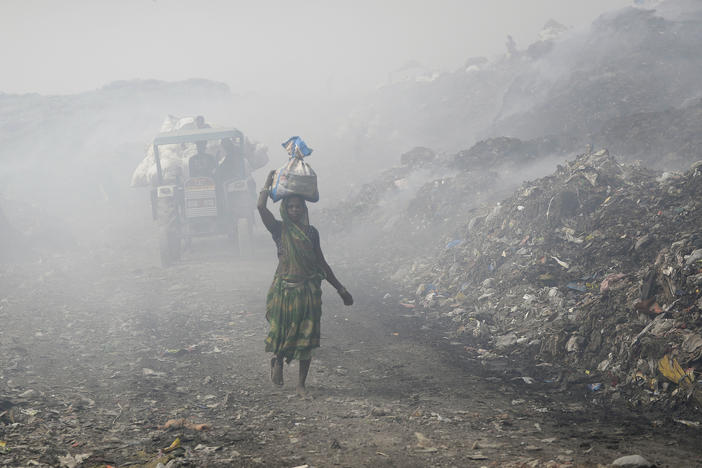 People work at a landfill in India that's full of plastic bags. Members of the United Nations are negotiating a treaty that's aimed at cutting plastic pollution globally.