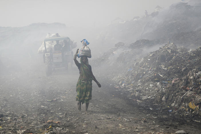 People work at a landfill in India that's full of plastic bags. Members of the United Nations are negotiating a treaty that's aimed at cutting plastic pollution globally.