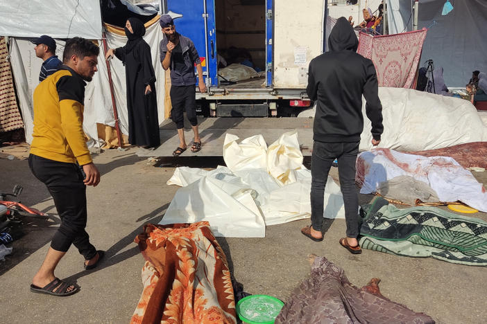 People check the bodies of victims killed in a reported Israeli strike, as they lie on the ground in the vicinity of Gaza City's Al Shifa hospital compound on Friday.