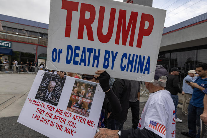 Supporters of former President Donald Trump hold anti-China signs as Trump visits an ice cream shop during in September.