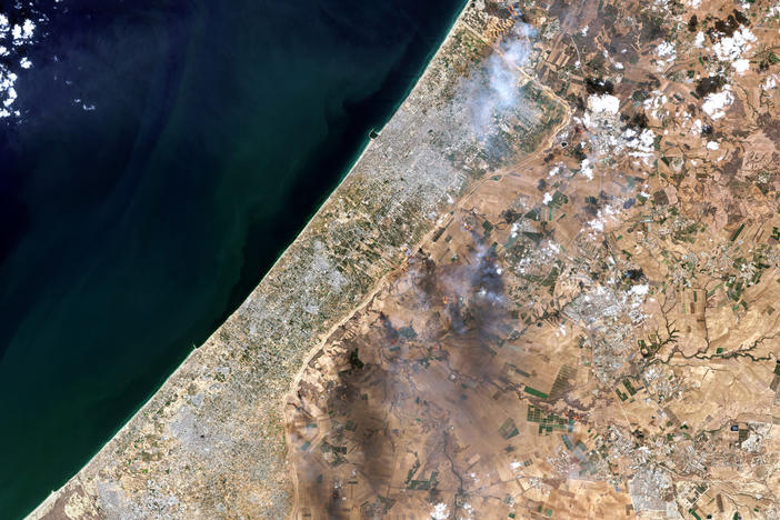 A satellite view shows smoke along the Gaza-Israel border on Oct. 7 in an image combining natural with shortwave-infrared highlights. The image came from a Copernicus Sentinel satellite run, by the EU space program.