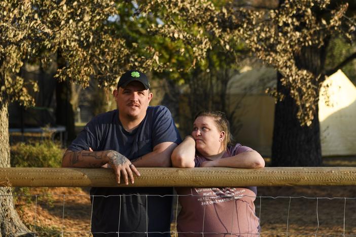 Army veteran Raymond Queen stands with his wife Rebecca Queen outside their home in Bartlesville, Okla.