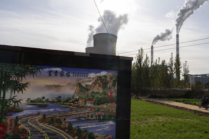 A resident rides past the Guohua Power Station in northern China's Hebei province. China and the U.S. have pledged to accelerate their efforts to address climate change ahead of a major U.N. meeting on the issue.