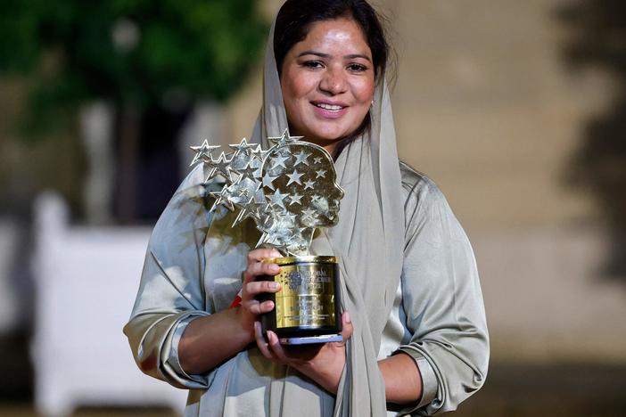 Pakistani teacher Riffat Arif, known as Sister Zeph, is the 2023 winner of the Varkey Foundation Global Teacher Prize. She holds a trophy presented at a dinner in her honor in Paris. She says she faced bad treatment from her teachers at school and dreamed of "a teacher who gives equal respect and love to children with no difference. I could not find that teacher, so I will be that teacher."