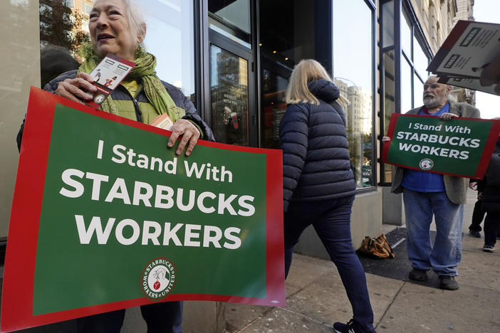 People hold signs supporting Starbucks workers outside a Starbucks on New York's Upper West Side on Thursday.