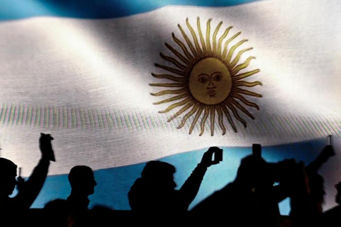 Against a backdrop of an Argentine flag, supporters of presidential candidate for La Libertad Avanza Alliance, Javier Milei, record with their mobile phones as he speaks during a campaign appearance.