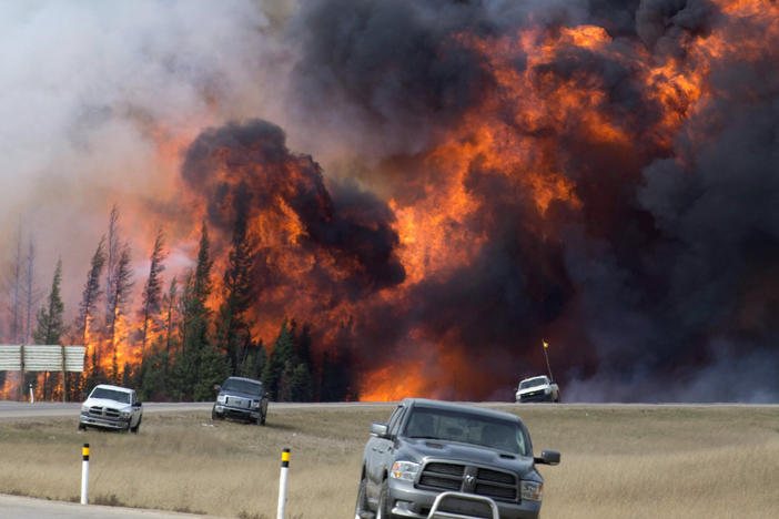A wildfire burns south of Fort McMurray, Alberta, near Highway 63 on Saturday, May 7, 2016. A book about an inferno that ravaged a Canadian city and has been called a portent of climate chaos has won Britain's leading nonfiction book prize.