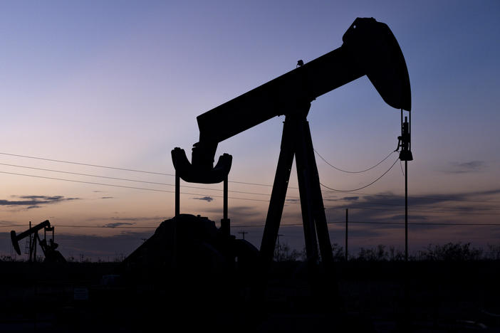 The sun sets behind pumpjacks on Sept. 15, 2021, in the oilfields of Penwell, Texas.