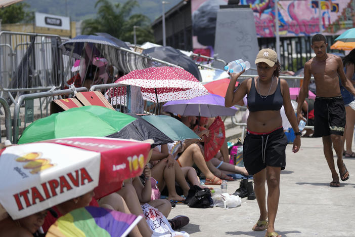 Street vendors sell bottled water to Taylor Swift fans amid a heat wave before her Eras Tour concert outside the Nilton Santos Olympic stadium in Rio de Janeiro, Brazil, Saturday, Nov. 18, 2023.