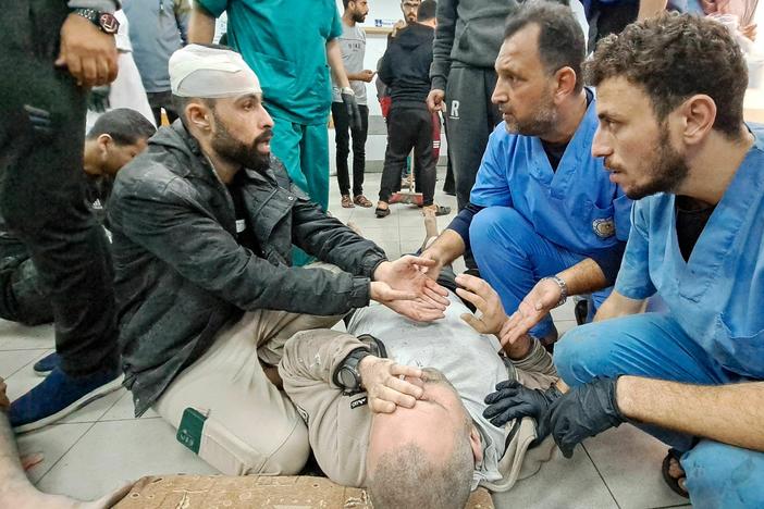 Palestinian medics listen to a man as the wounded are brought to the Kamal Adwan hospital in Beit Lahia in Gaza following Israeli bombardment on Tuesday. The hospital is situated just a few miles south of the Indonesian hospital, which was hit Monday by Israeli shelling, according to Palestinian officials.