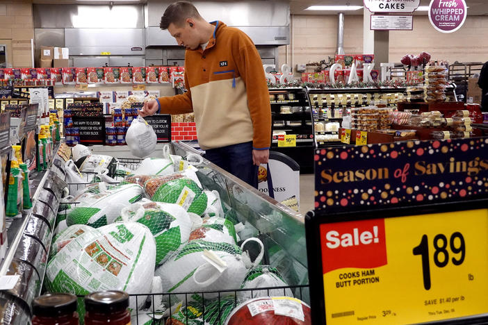 A customer in Chicago looks for turkeys offered for sale on Nov. 20, 2023, ahead of the Thanksgiving holiday. Turkey prices have fallen — but the cost of many groceries are still higher.