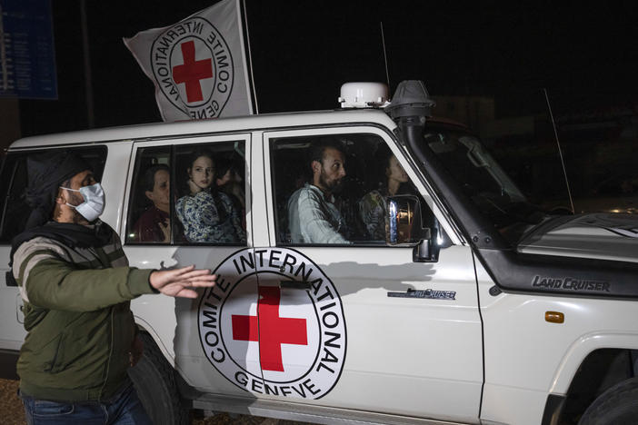 A Red Cross vehicle carrying Israeli hostages drives by at the Gaza Strip crossing into Egypt in Rafah on Saturday, Nov. 25, 2023.