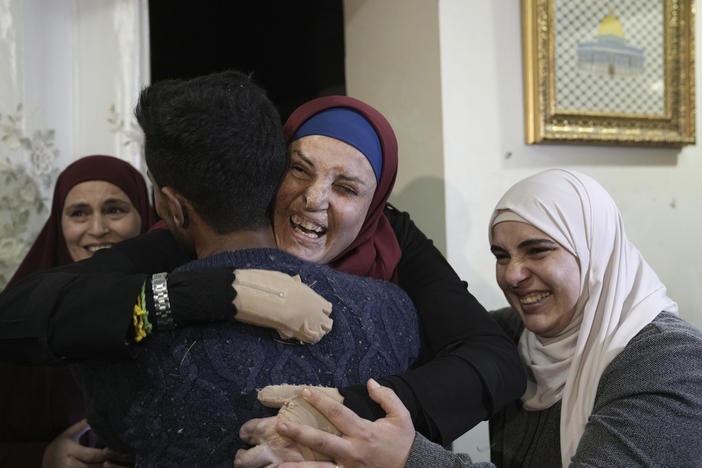Israa Jaabis, center, a Palestinian prisoner released by Israel, is hugged by relatives as she arrives home in the east Jerusalem neighborhood of Jabel Mukaber, early Sunday Nov. 26, 2023.