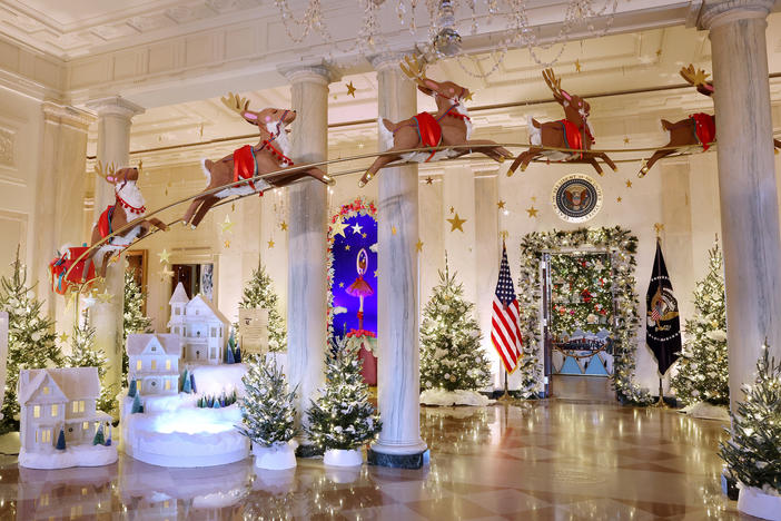 Santa Claus in his sleigh and a team of reindeer fly through the columns of the Entrance Hall of the White House. The theme for this year's White House decorations is "Magic, Wonder and Joy."