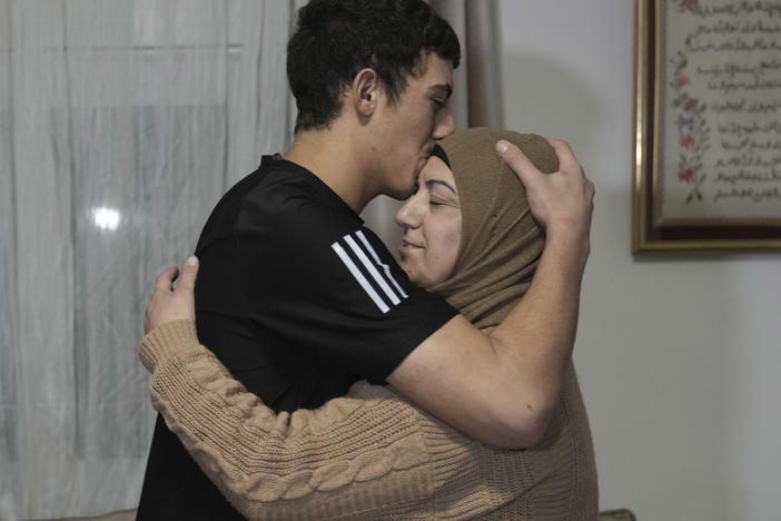 Released Palestinian prisoner Muhammad Abu Al-Humus, 17, hugs his mother after arriving home in the east Jerusalem neighborhood of Issawiya, early Tuesday. Eleven Israelis were also released in the latest Israel-Hamas swap of captives.